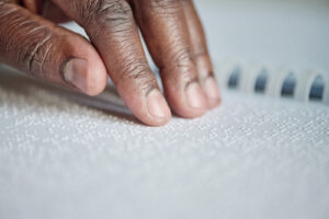 A person with a vision disability reading braille.